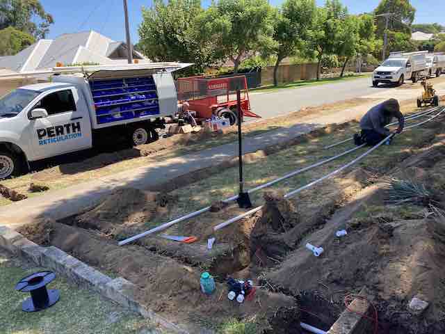 Perth Reticulation ute and trailer parked beside open trenches with PVC pipes laid along a verge install.