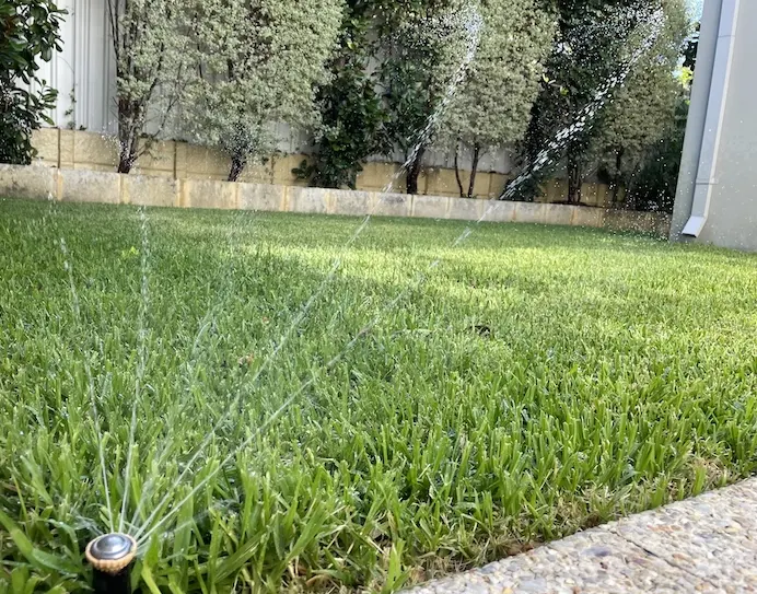 New reticulation sprinkler system watering a Perth lawn